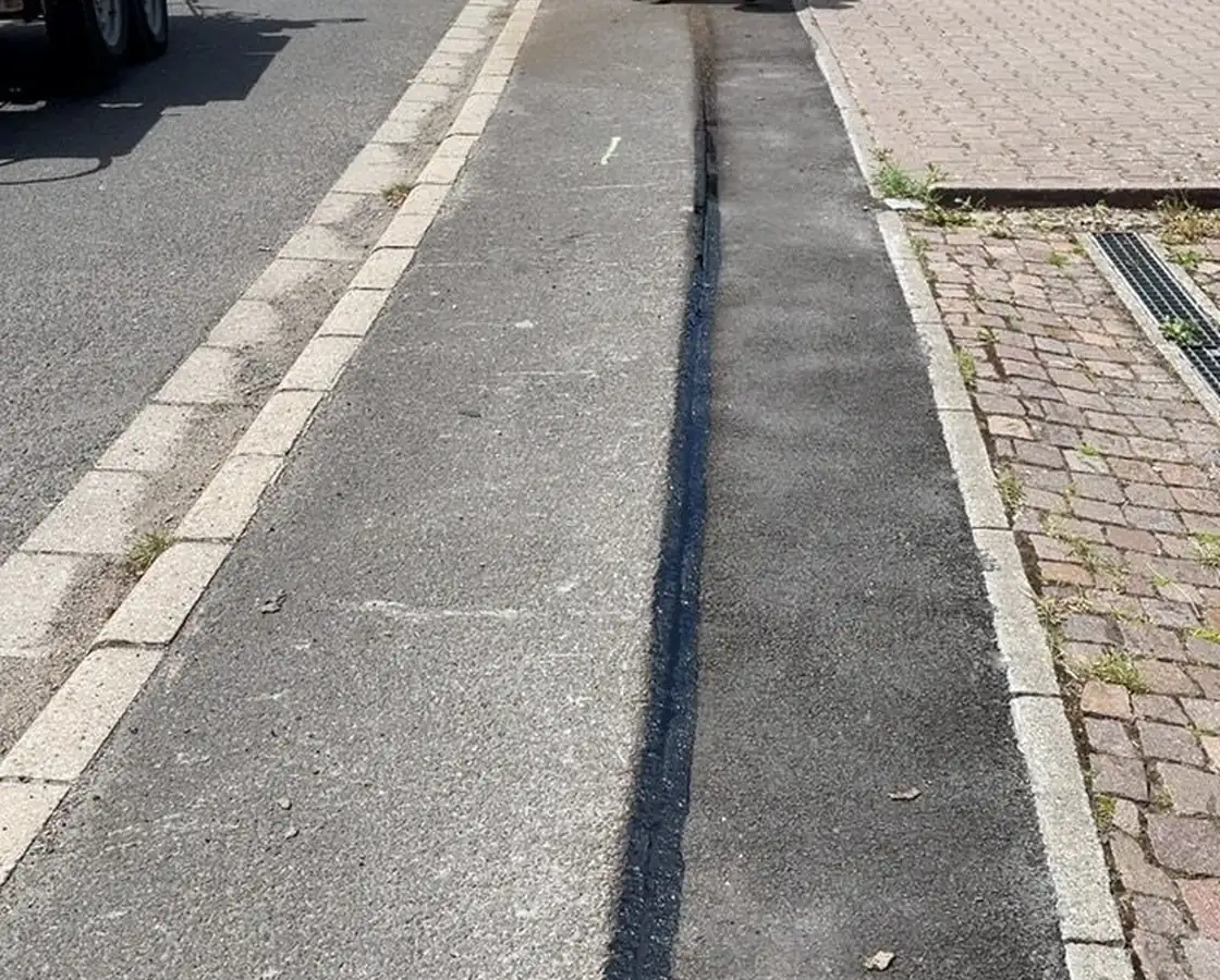 Wiederhergestellte Asphaltnaht über der verlegten Trasse