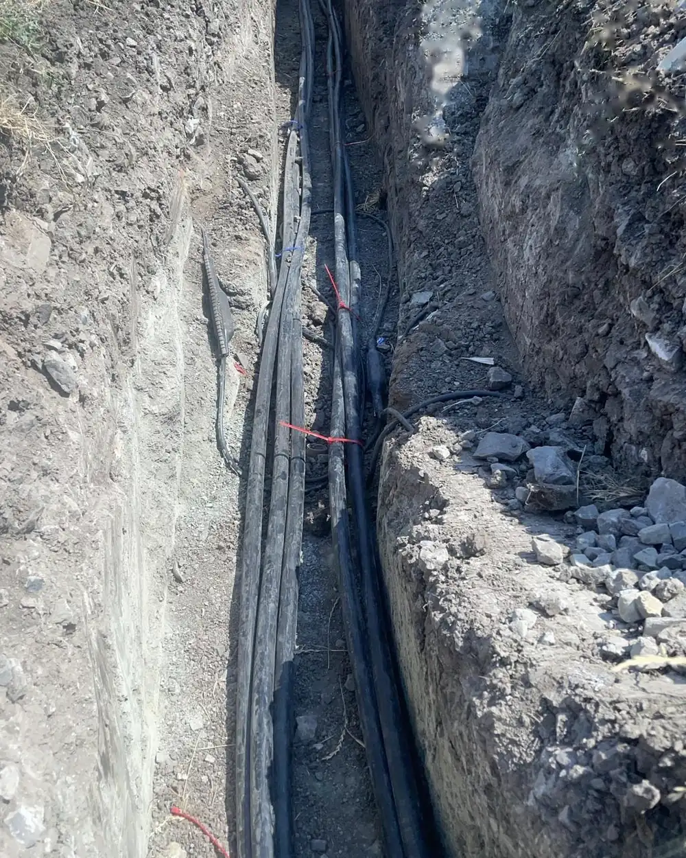 Verlegtes Kabel im offenen Graben, Sandbettung sichtbar