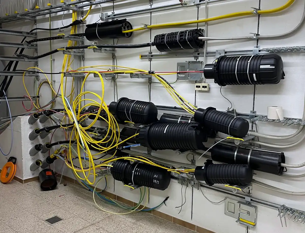 Montierte Muffen an der Wand im Technikraum, gelbe Fasern geführt